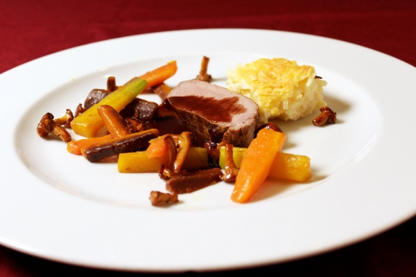 Lende van wildzwijn met vlierbessensaus, selderij gratin, wortels en cantharellen
